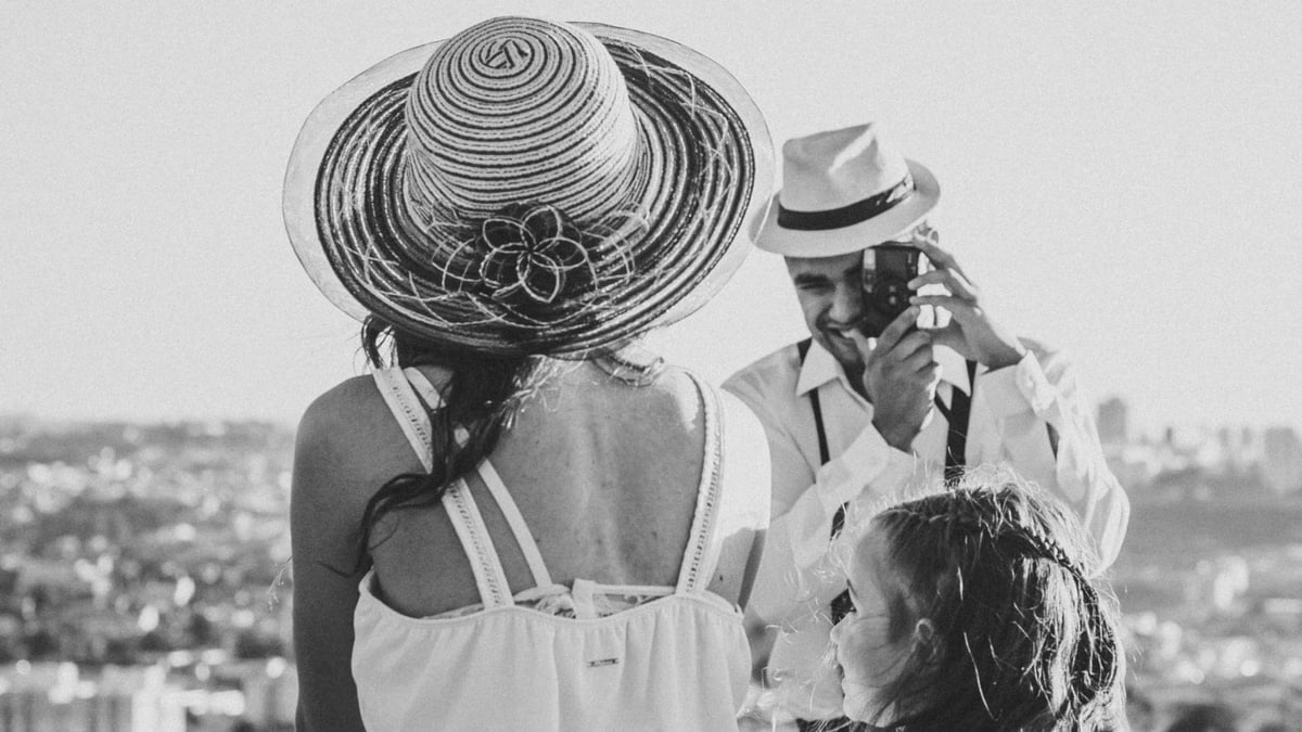 A black and white family portrait of a couple and child overlooking Sorocaba, Brazil on a sunny day.